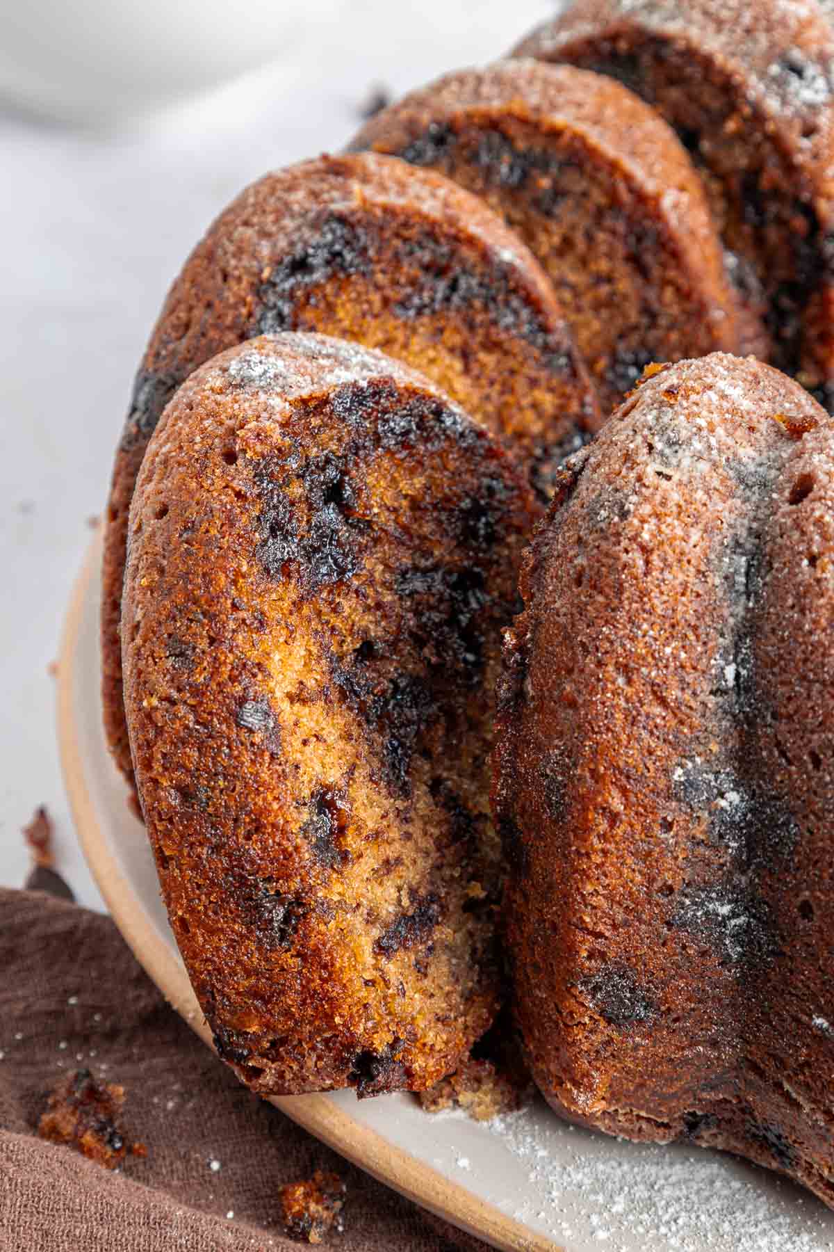 Banana Chocolate Chip Cake with slice hanging out of the banana bundt cake.