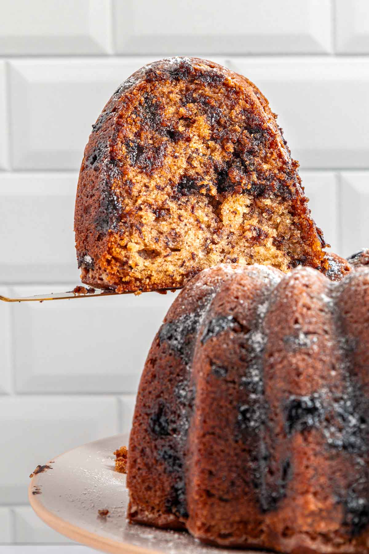 Banana Chocolate Chip Cake with slice being removed from banana bundt cake.