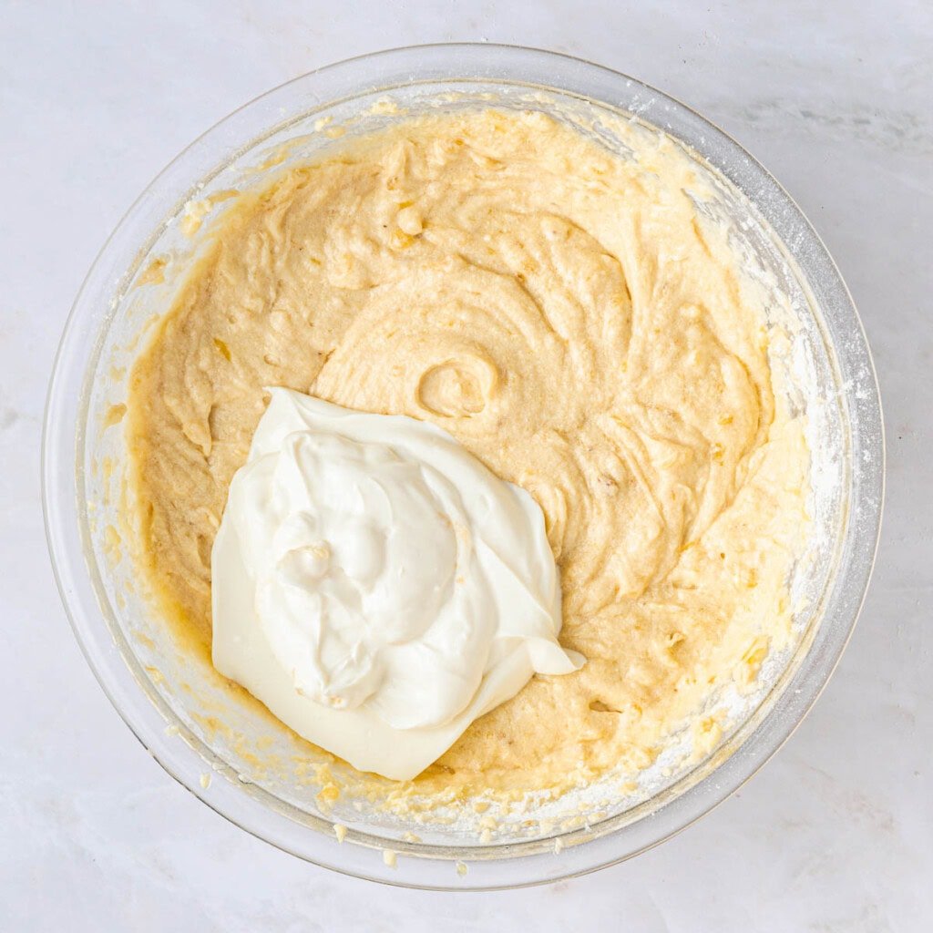 Adding Greek yogurt to banana bundt cake batter.