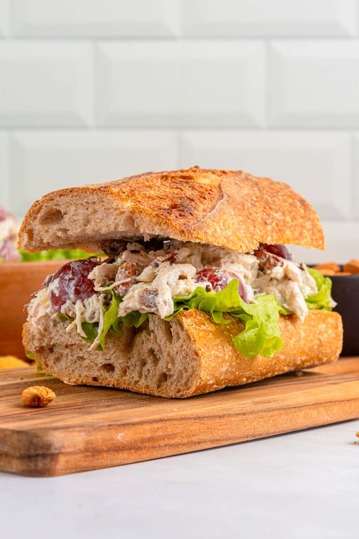 Chicken salad recipe with grapes on sandwich with lettuce.