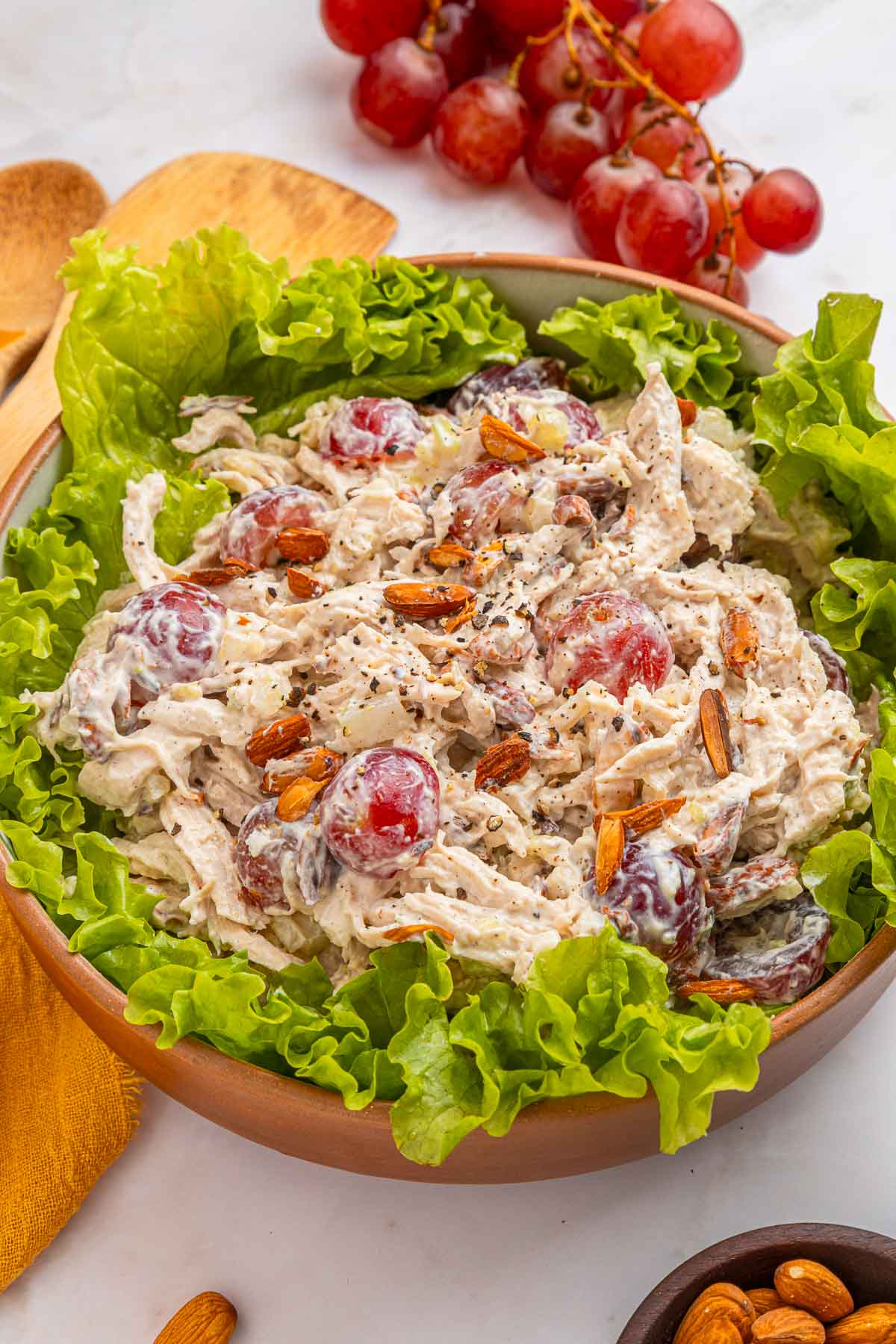 Chicken and grape salad in wooden bowl.