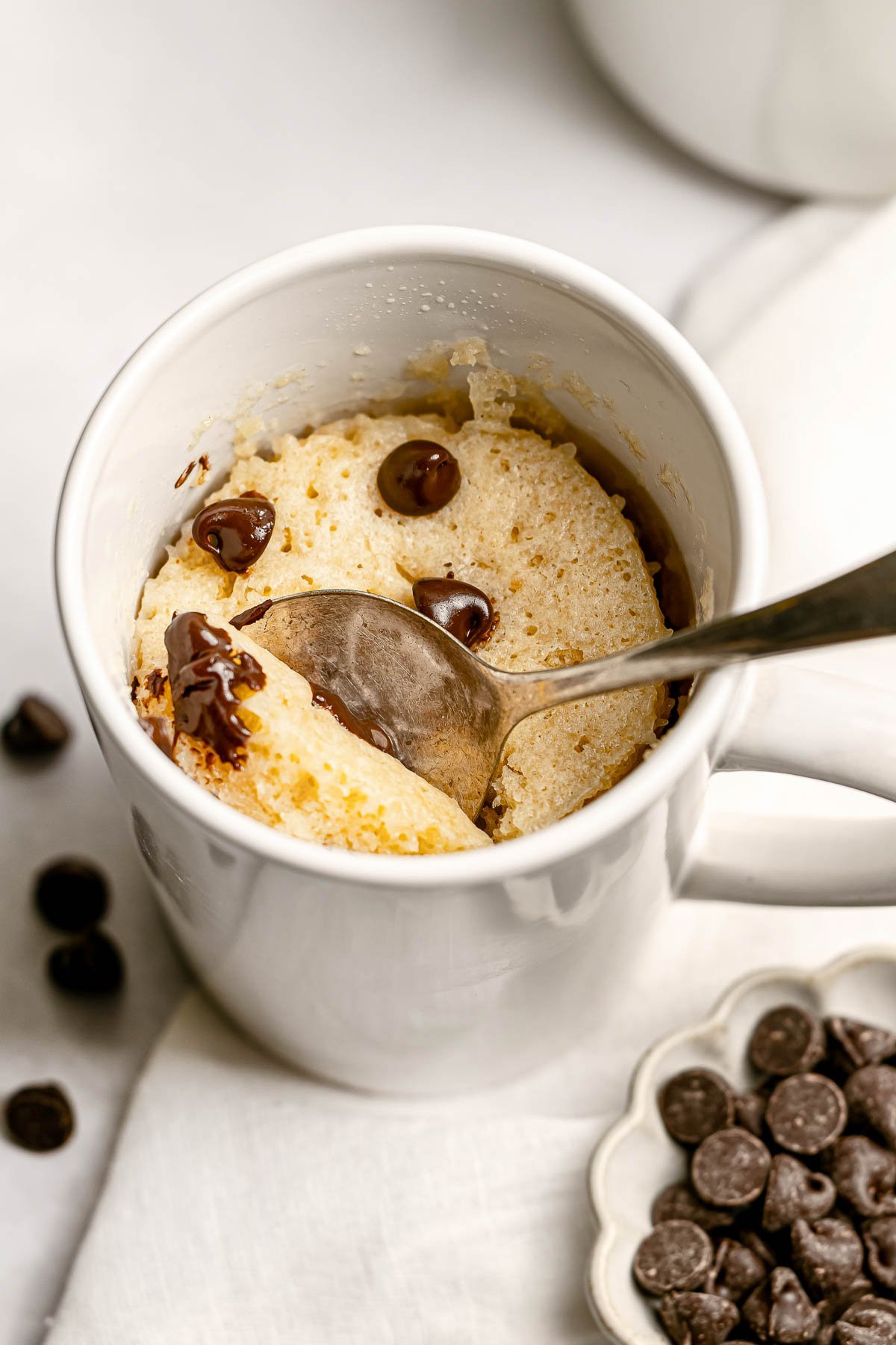 Chocolate Chip Mug Cake with spoon digging out a bite.