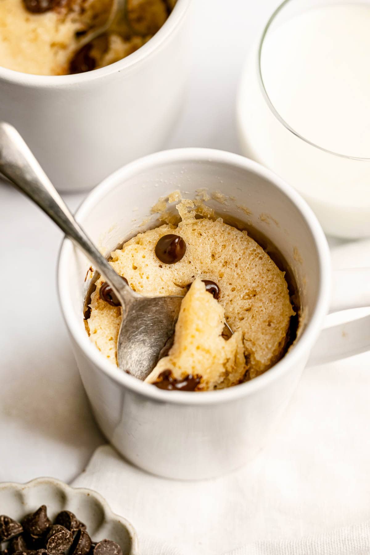 Chocolate Chip Mug Cake recipe with spoon in white mug.