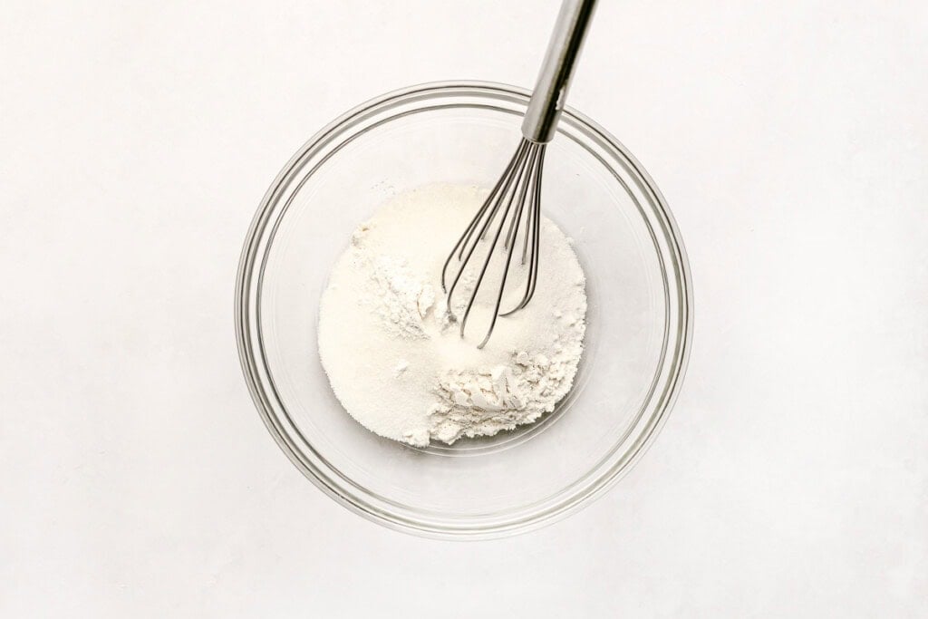 Dry ingredients in bowl with whisk.