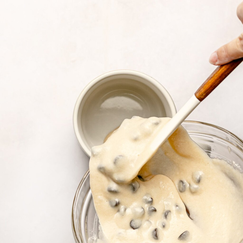 Chocolate Chip Mug Cake batter being scraped into mug.