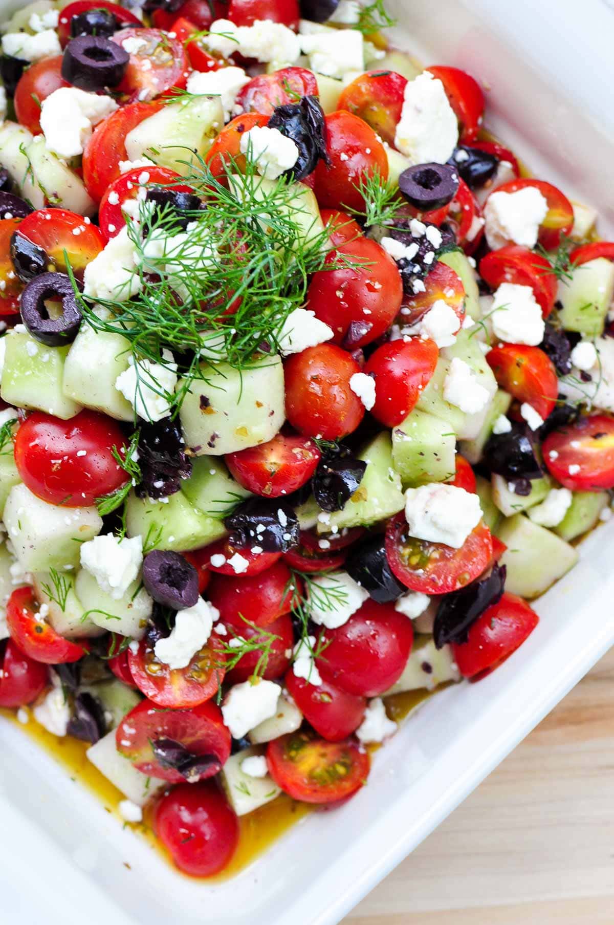 Cucumber Tomato Feta Salad aerial in bowl with olives and dill.