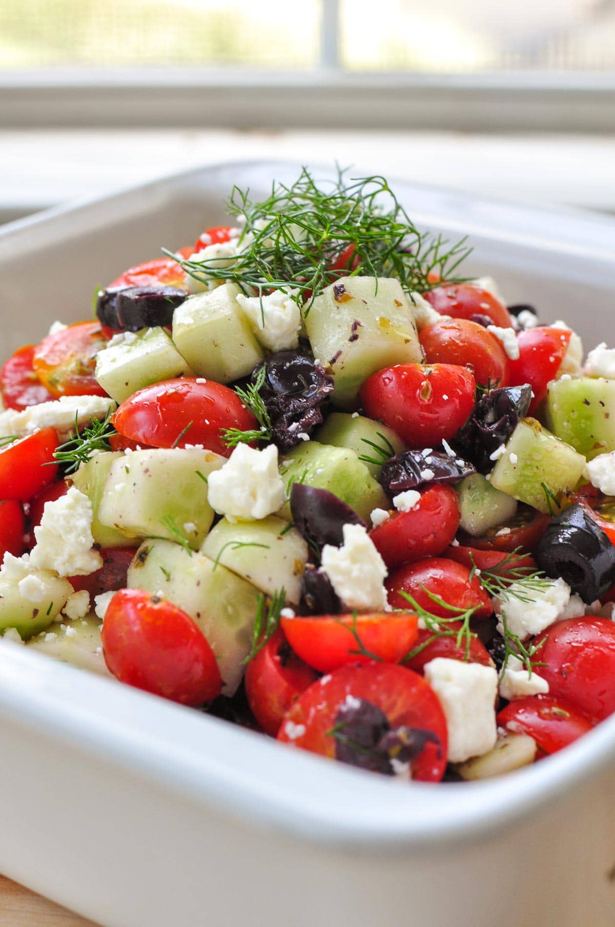 Cucumber Tomato Feta Salad in serving bowl with fresh dill on top.