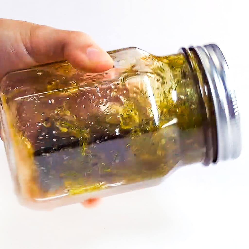 Shaking vinaigrette for tomato cucumber salad.