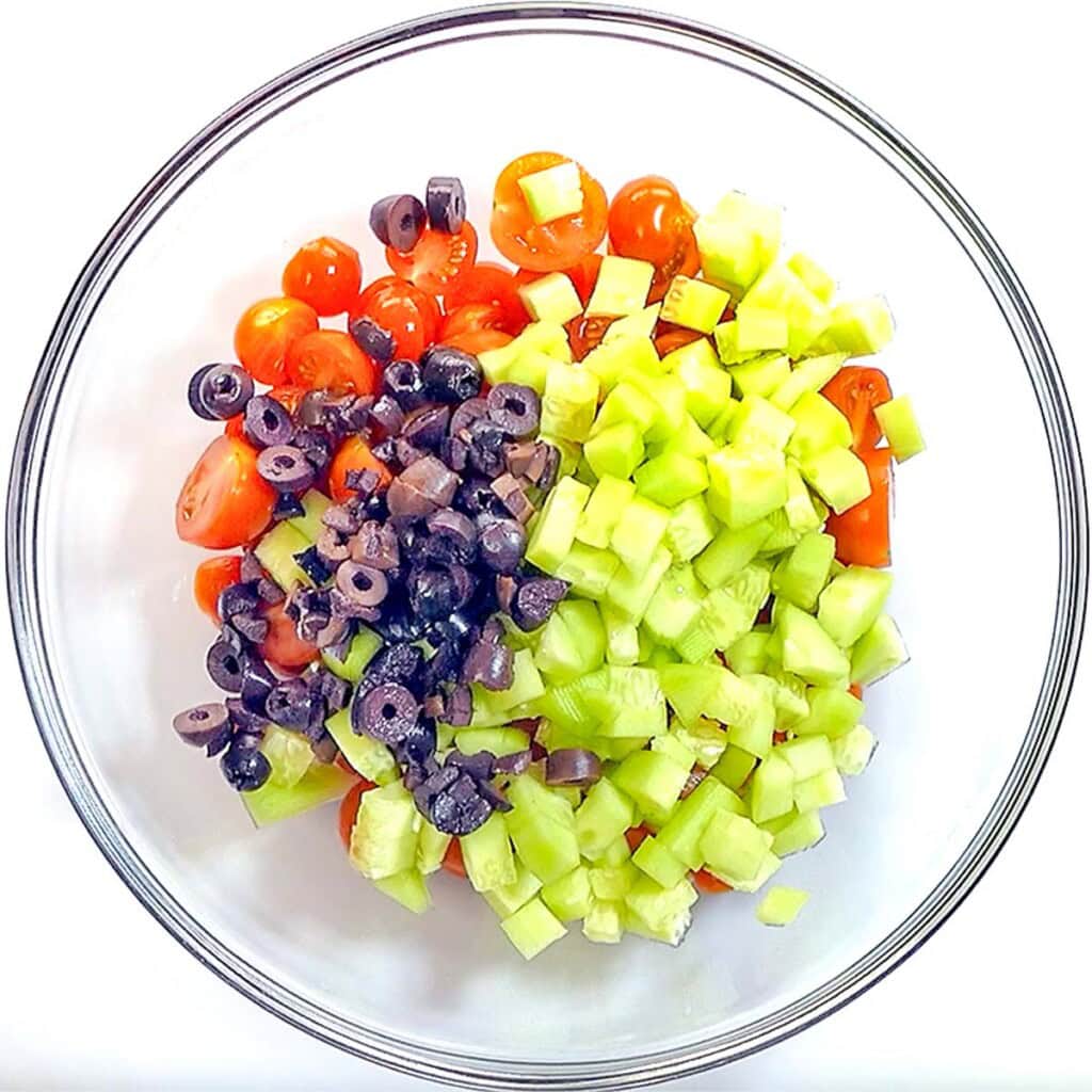 Adding olives to bowl.