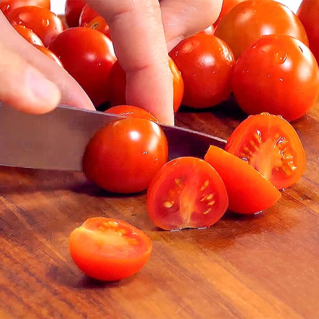 Slicing tomatoes in half.