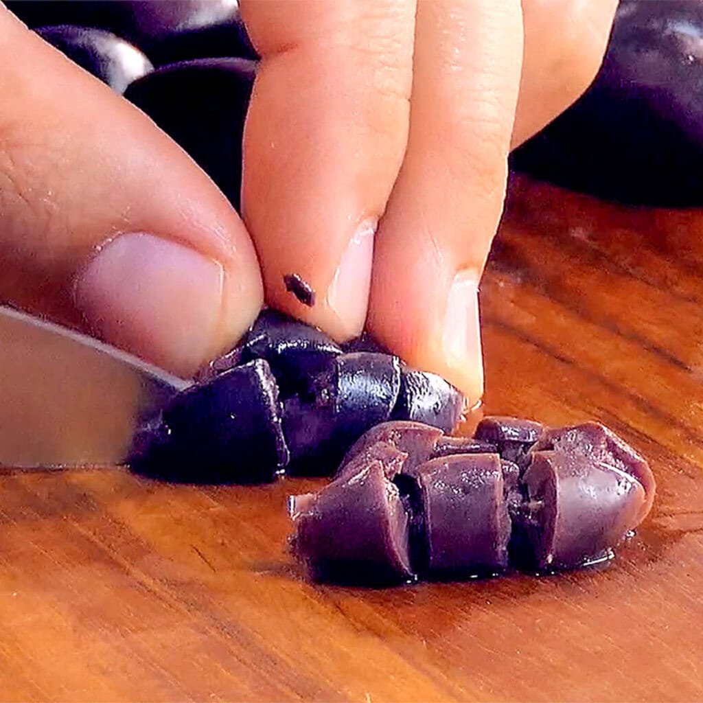 Dicing kalamata olives for cucumber tomato salad.
