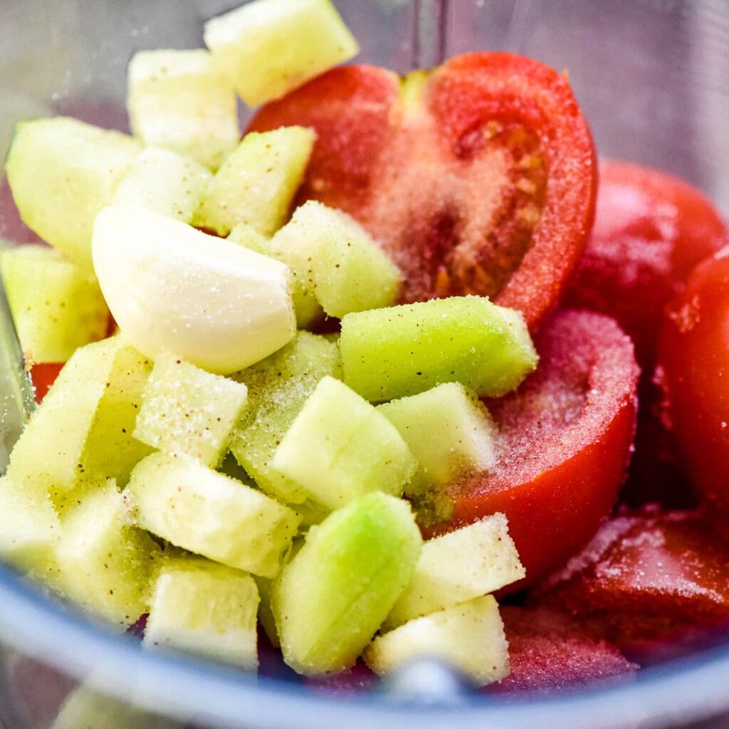 Gazpacho ingredients in blender with salt.
