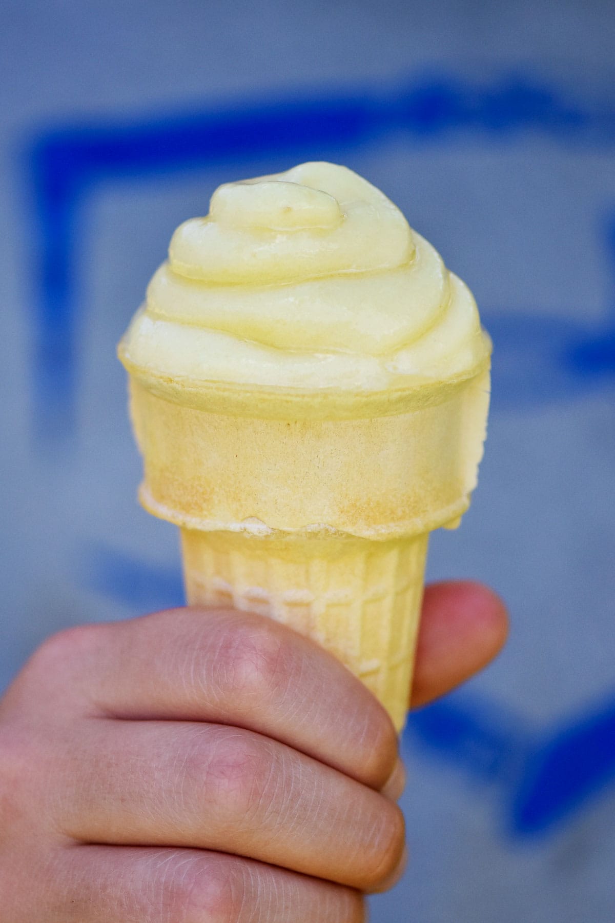 Dole whip pineapple on cone in hand.