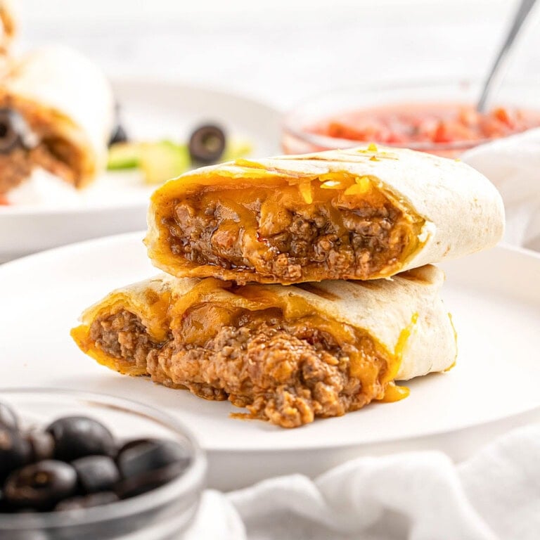 Beef and Bean Burritos cut in half on plate.