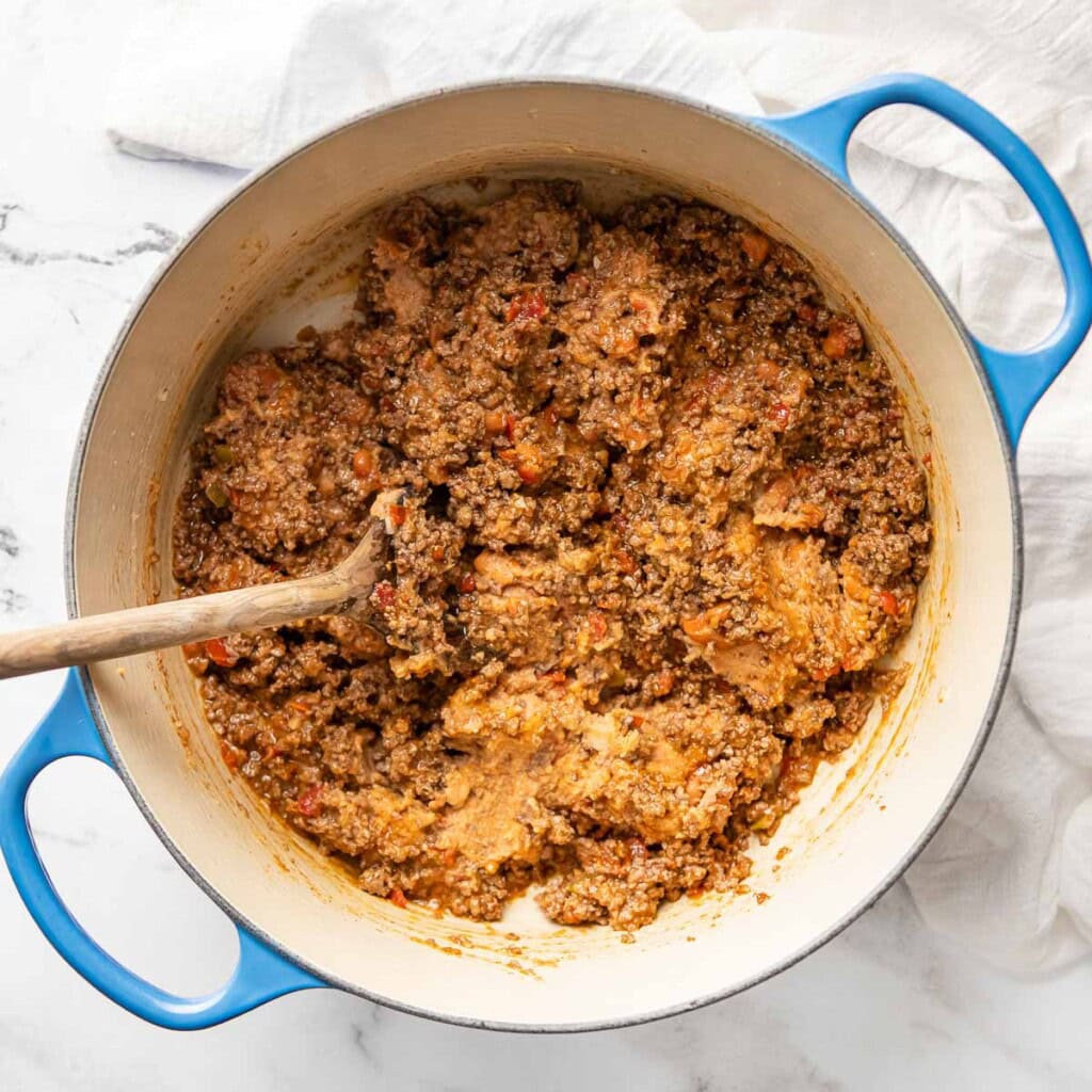 Stirring beans into beef for burrito recipe.