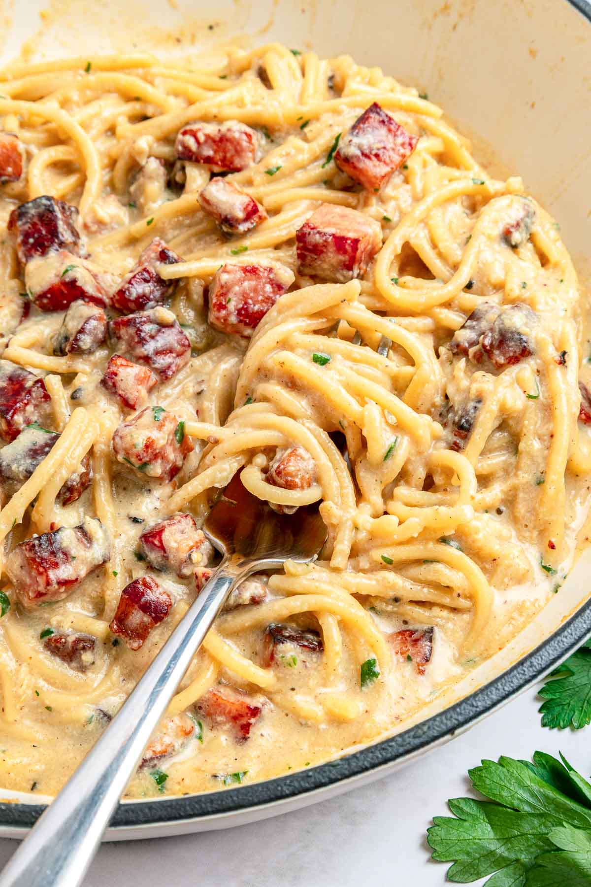 Carbonara Recipe with fork in skillet of pasta.