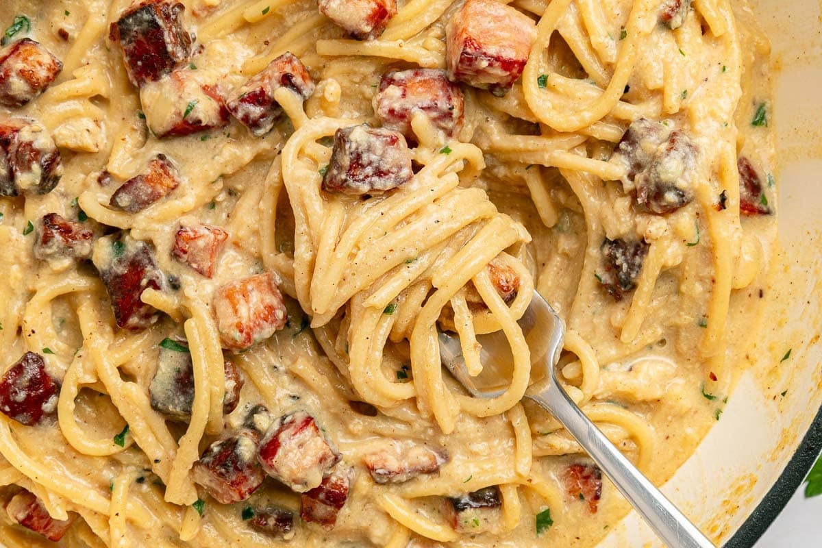 Carbonara Recipe aerial view on fork in pan.