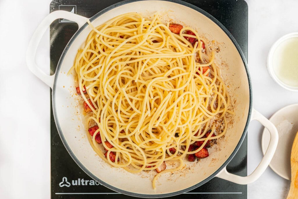 Adding spaghetti to Carbonara Recipe.