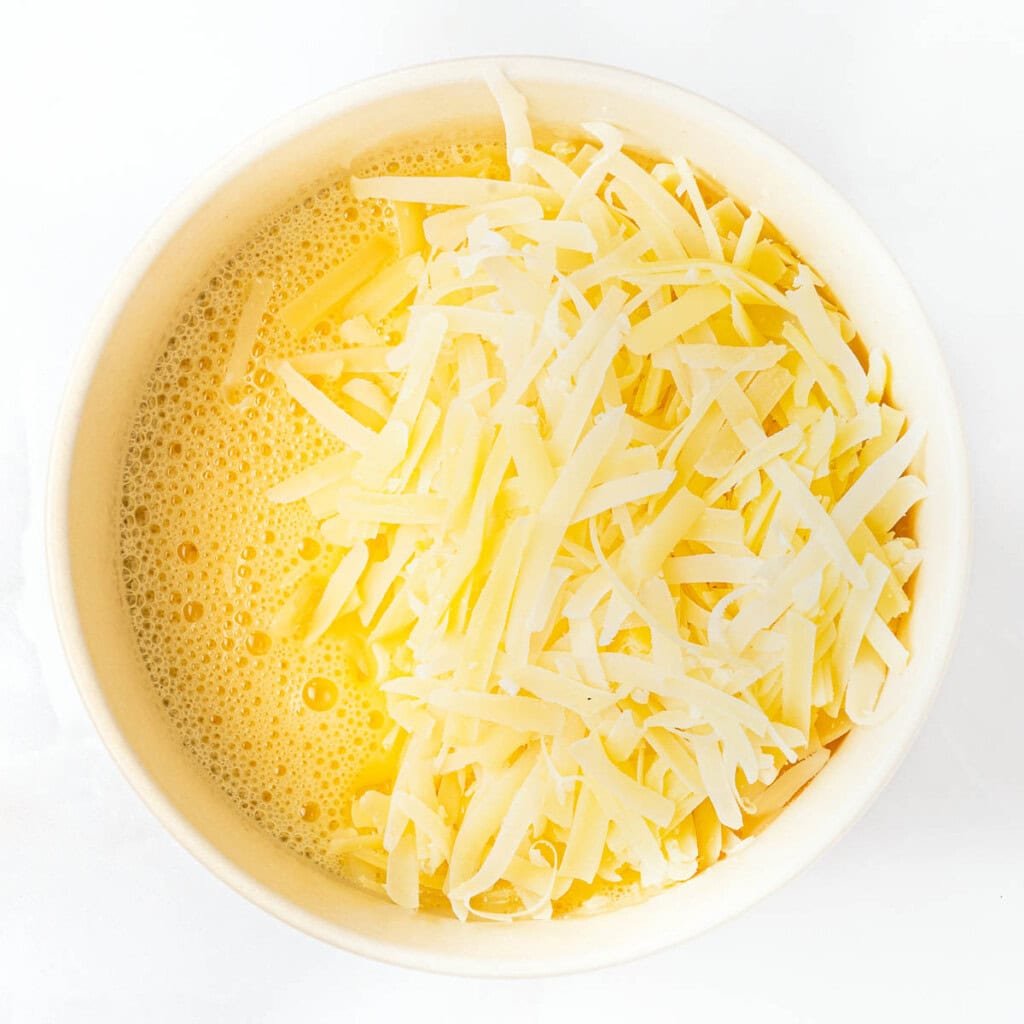 Eggs and Parmesan in bowl.
