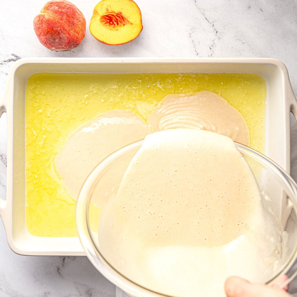 Pouring batter into butter for Easy Peach Cobbler recipe.