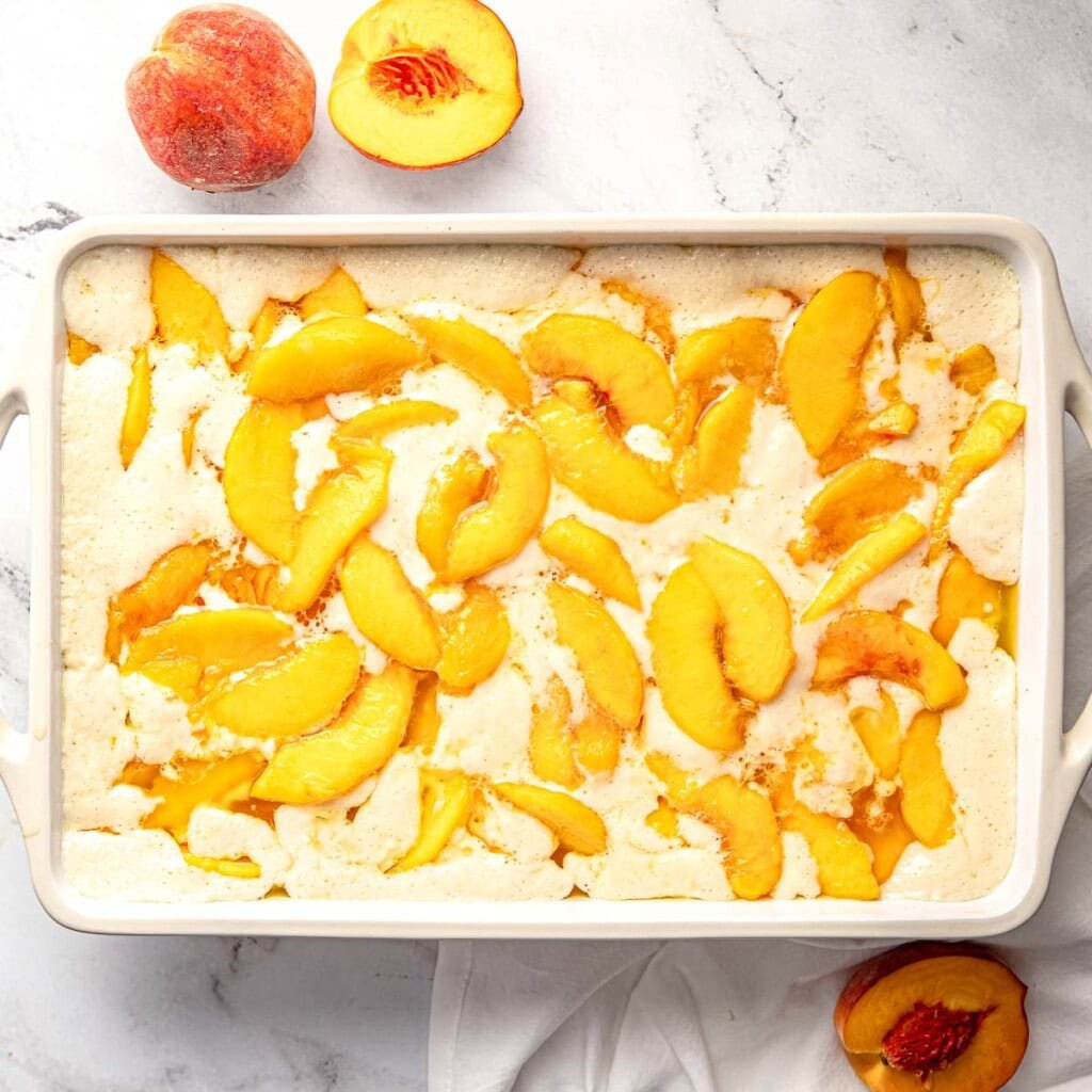 Southern peach cobbler recipe ready for sprinkling of cinnamon.