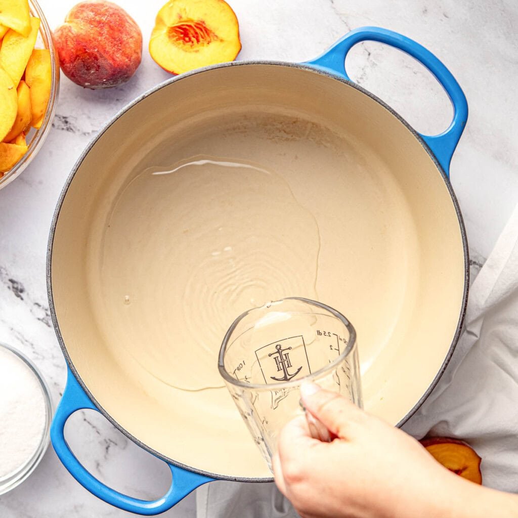 Pouring water in saucepan.