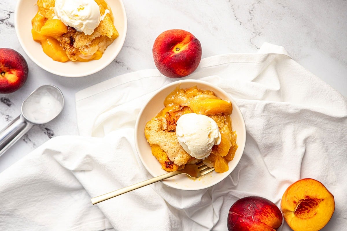 Easy Peach Cobbler aerial view in bowls with ice cream.