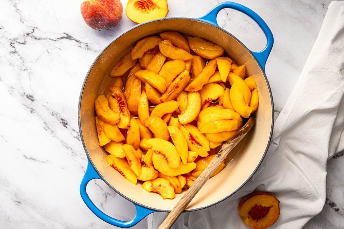 Simmering peaches in simple syrup for peach cobbler recipe easy.