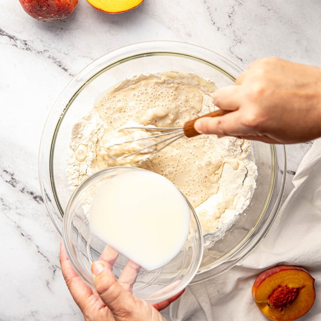 Whisking milk into dry ingredients.