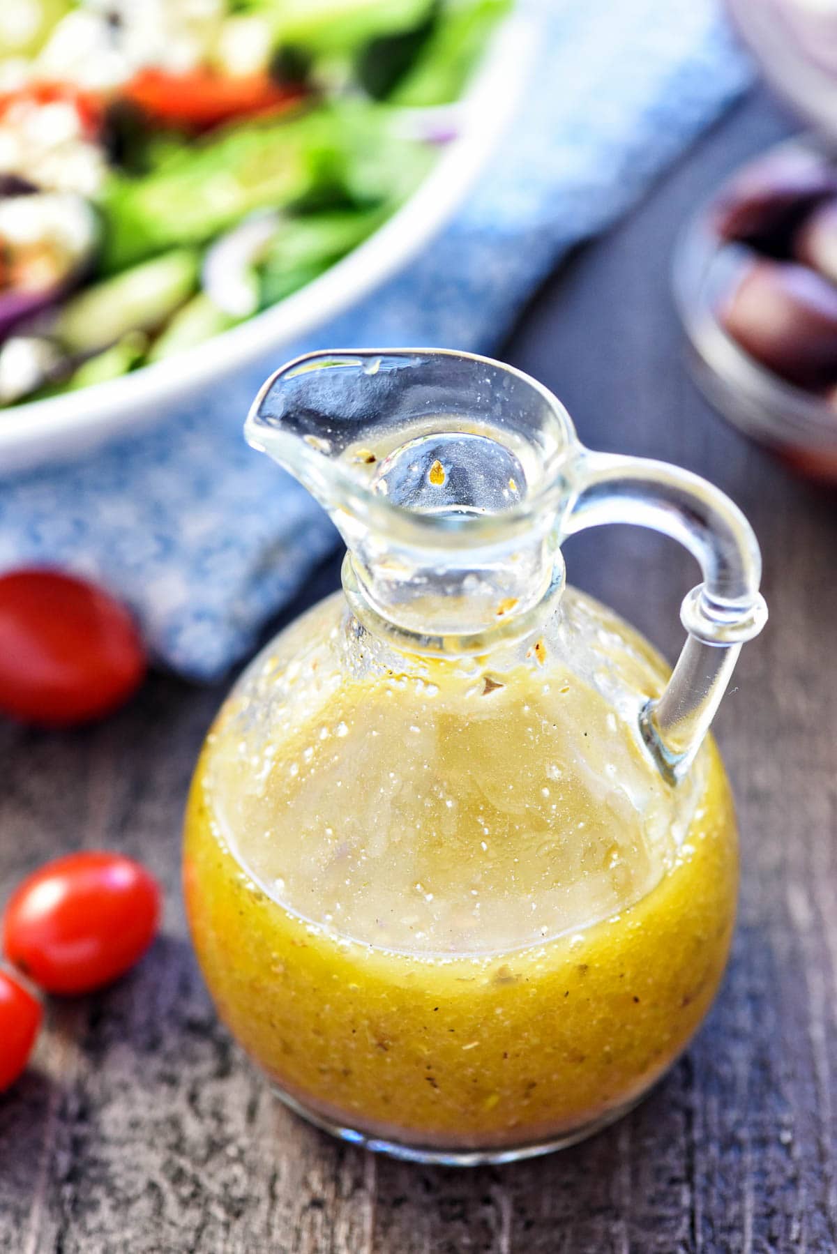 Greek Salad Dressing in clear glass bottle on table.
