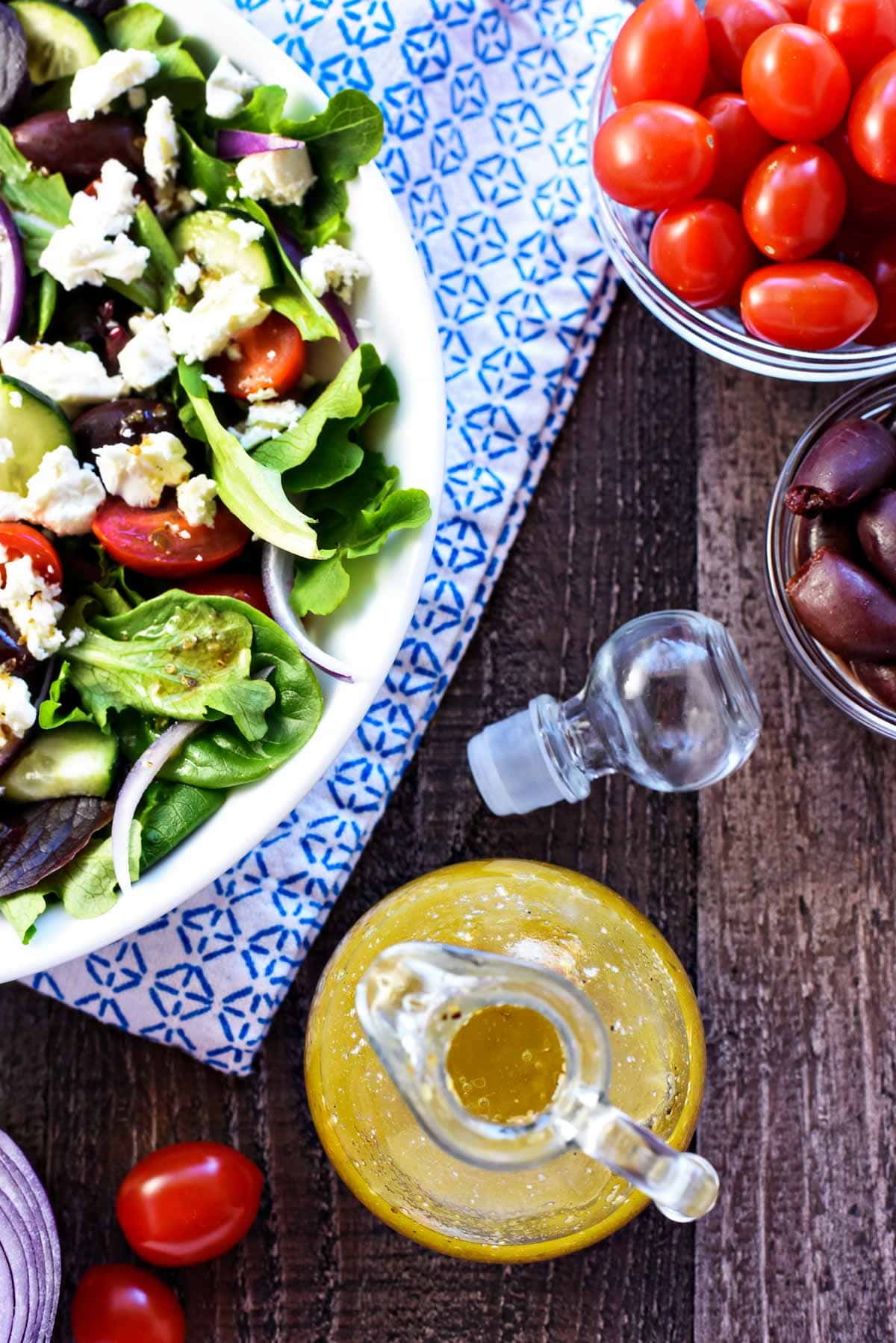 Greek Salad Dressing aerial view with Greek salad and ingredients.