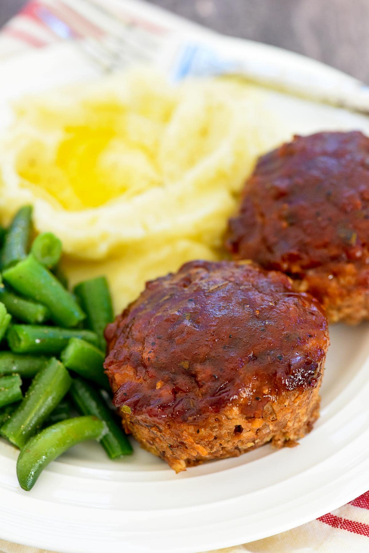 Meatloaf Muffins on plate with mashed potatoes and green beans.