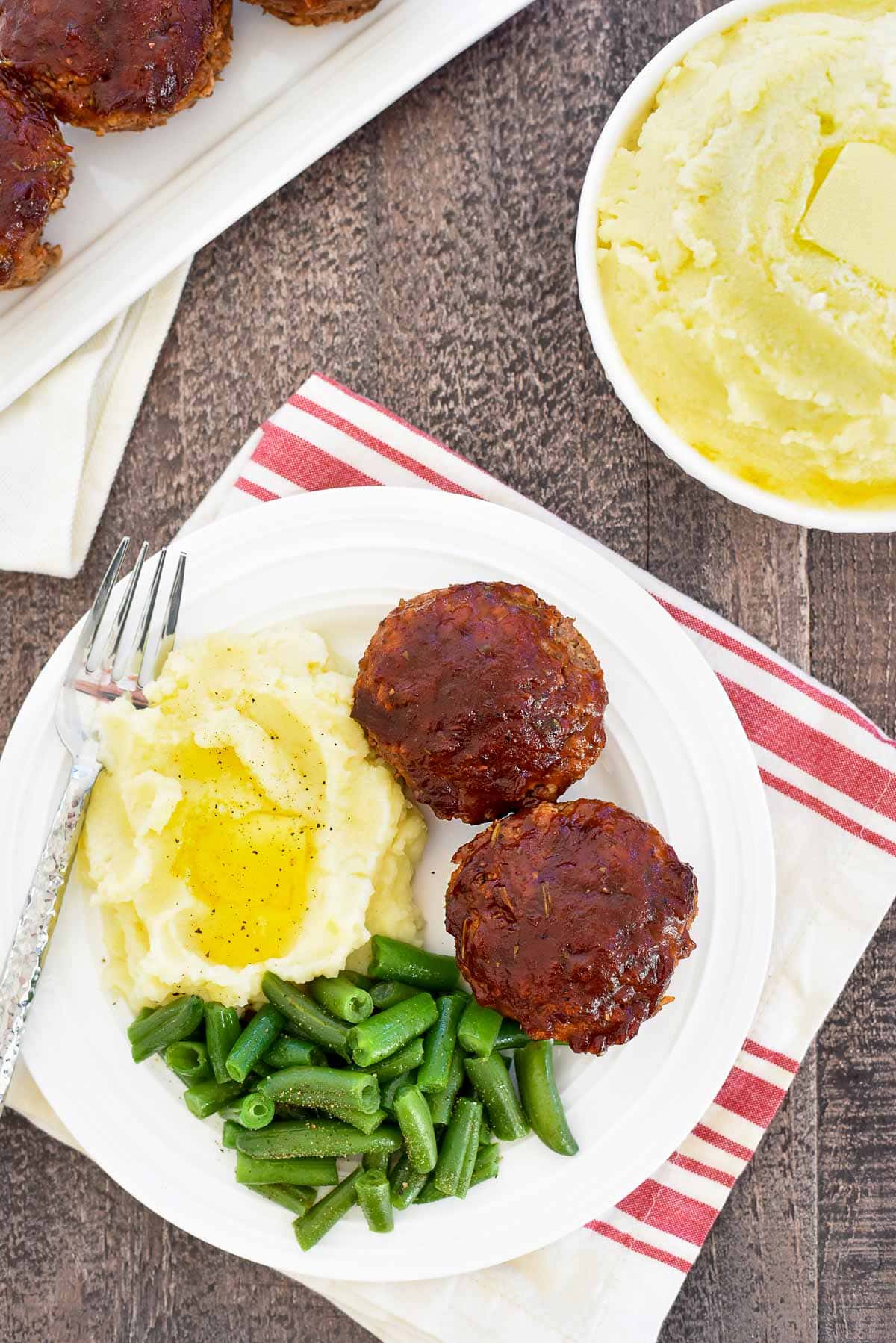 Meatloaf Muffins aerial view with mashed potatoes and green beans.