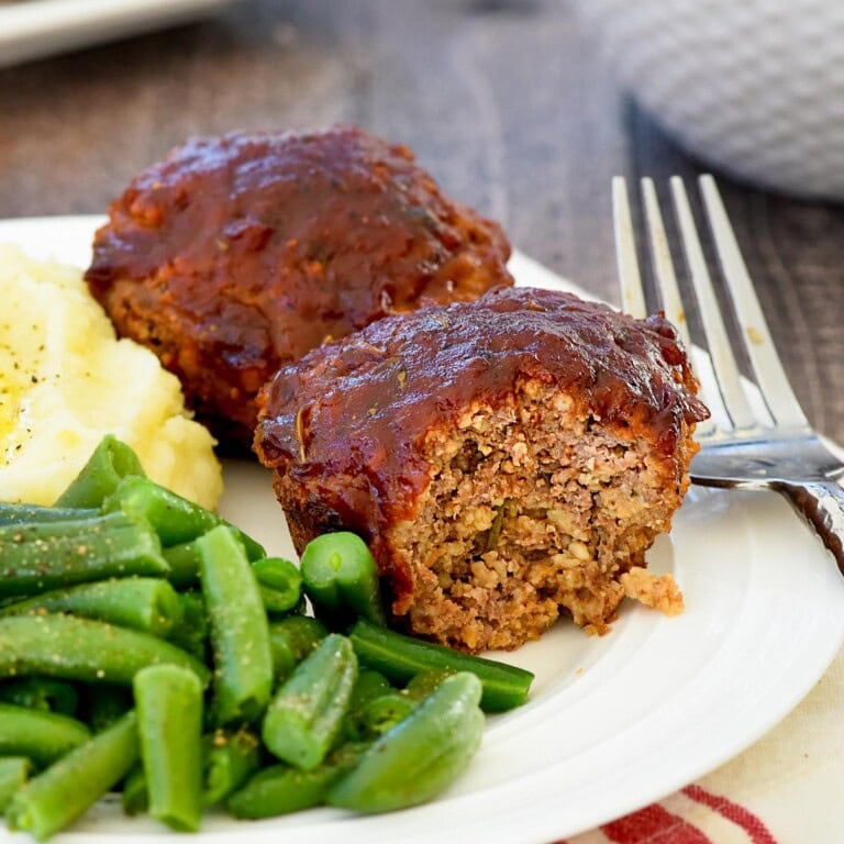 Meatloaf Muffins with missing bite and sides on plate.