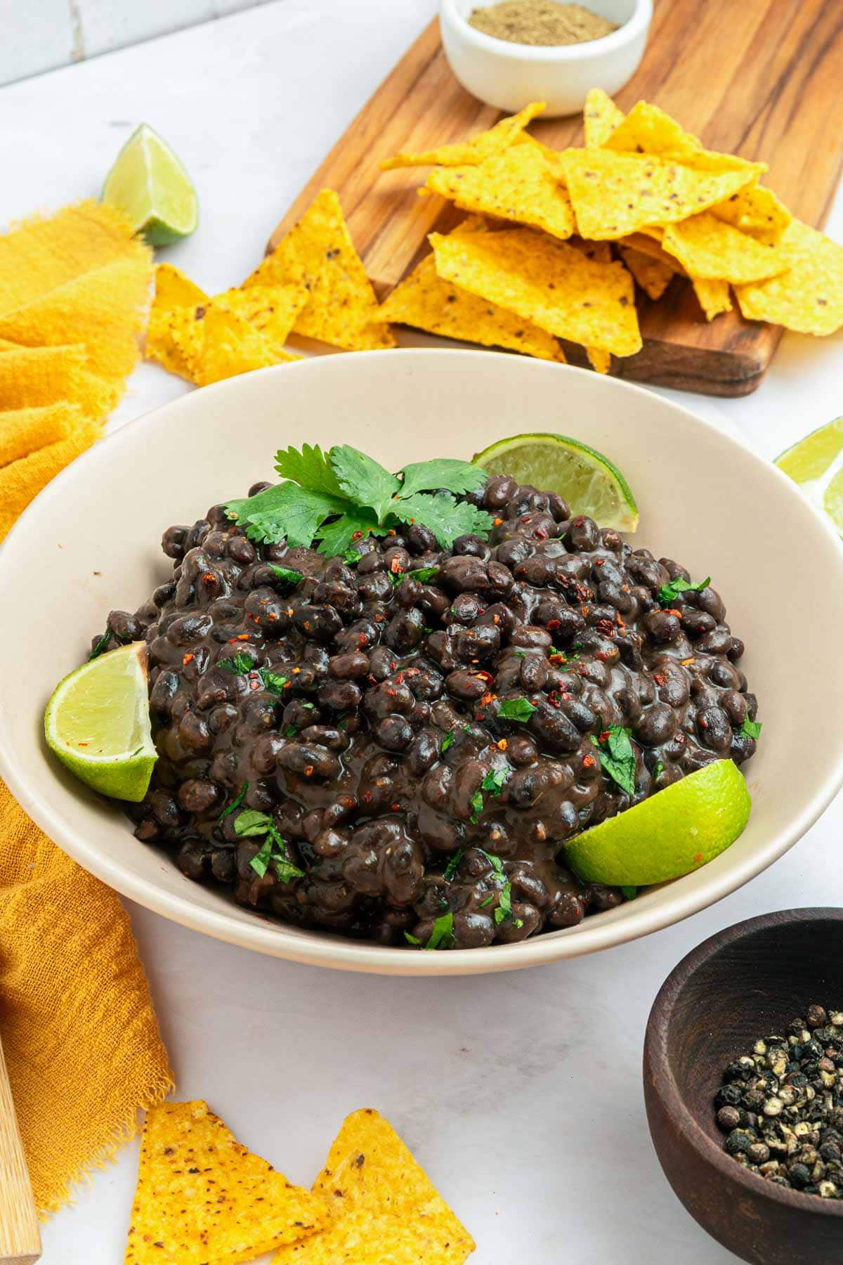 Seasoned Black Beans in bowl surrounded by tortilla chips.
