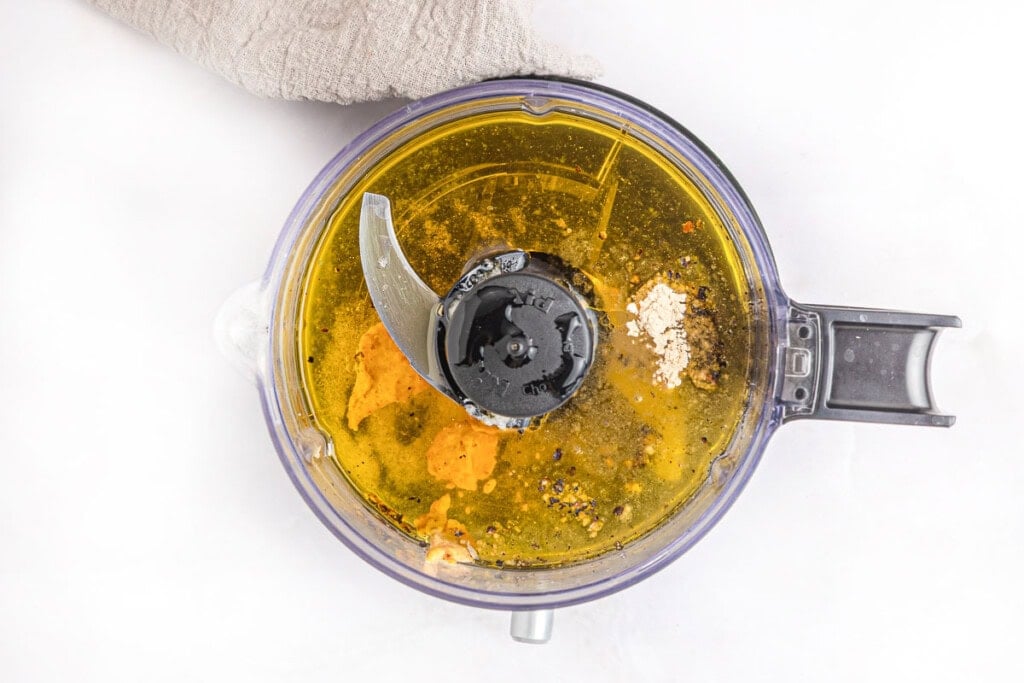 Oil, vinegar, and other ingredients in mini food processor.