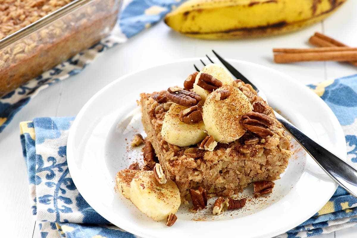 Banana Baked Oatmeal on plate with baking dish in background.