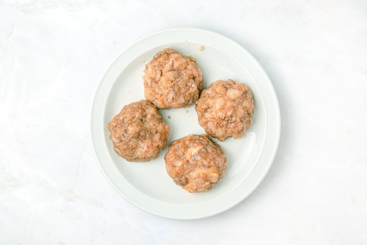 Chicken burger patties formed on plate.