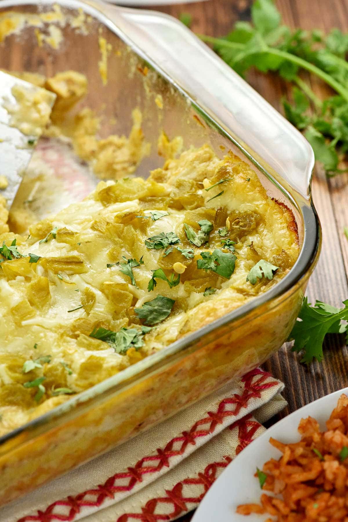 Chicken Enchilada Casserole in baking dish with missing scoop.