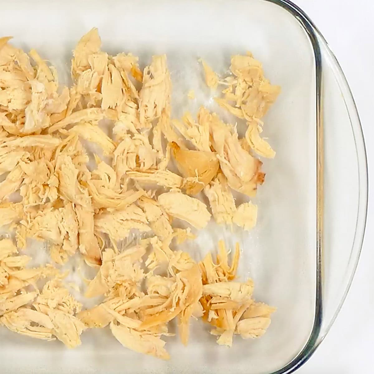 Chicken in baking dish for easy Chicken Enchilada Casserole.