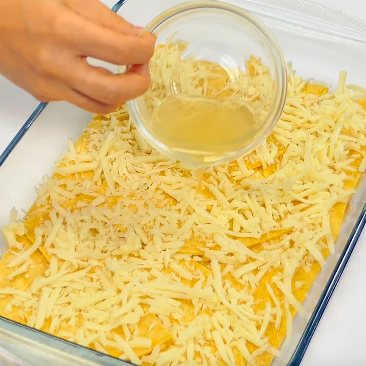 Pouring chicken broth over first set of layers.