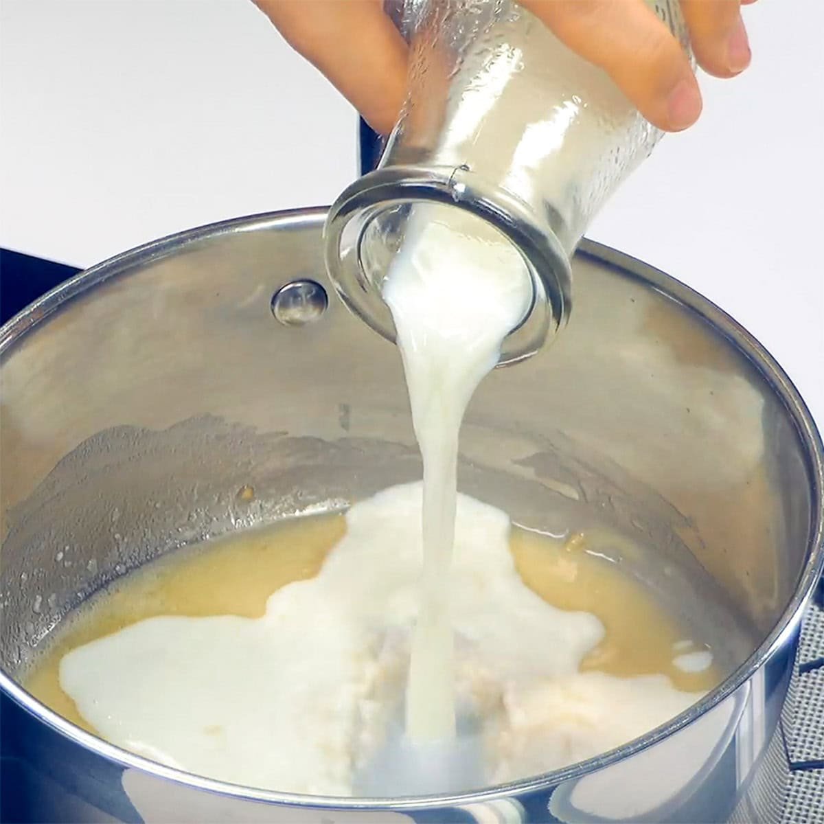 Adding milk to homemade sauce for Chicken Enchilada Casserole.