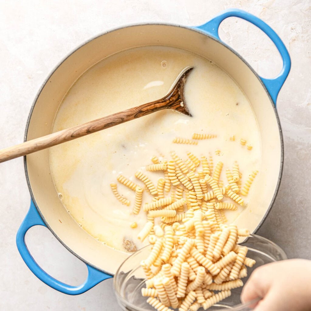 Adding pasta to pot.