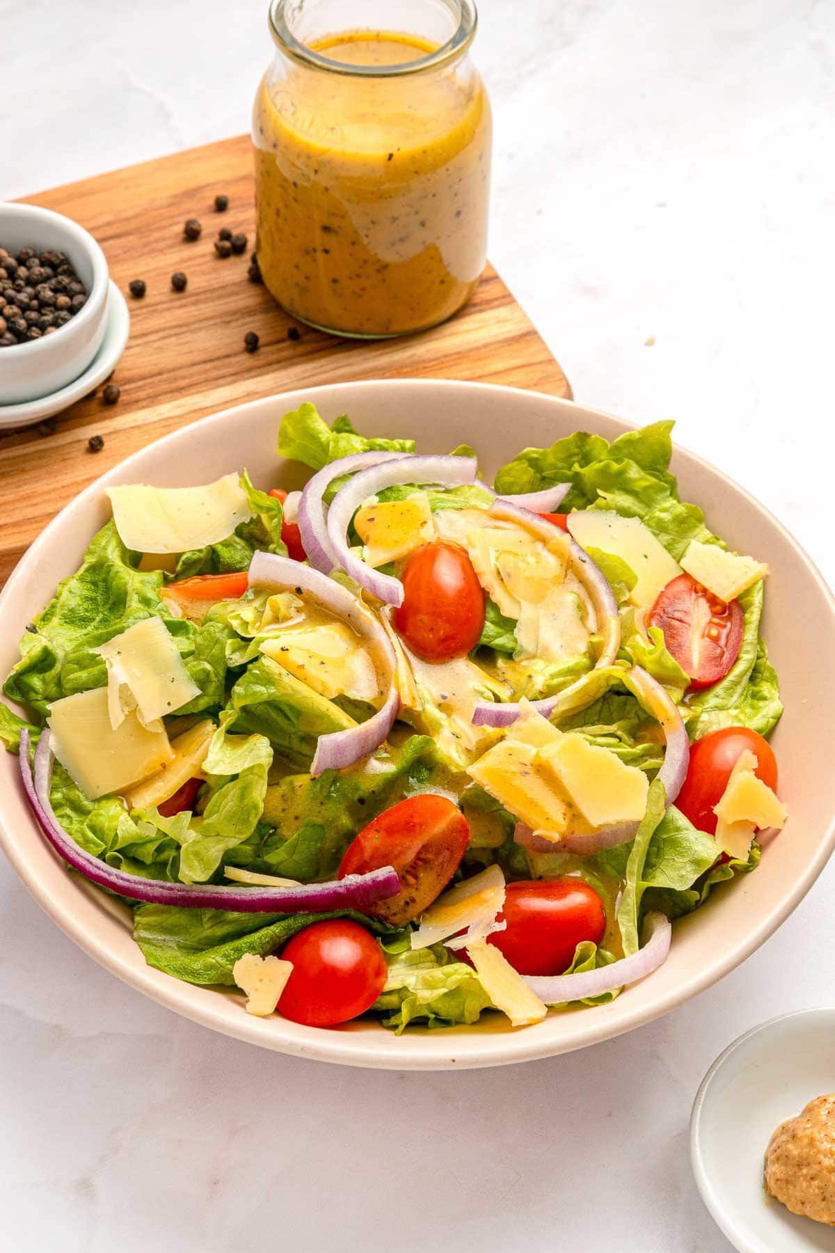 Red Wine Vinaigrette on salad in bowl with ingredients.