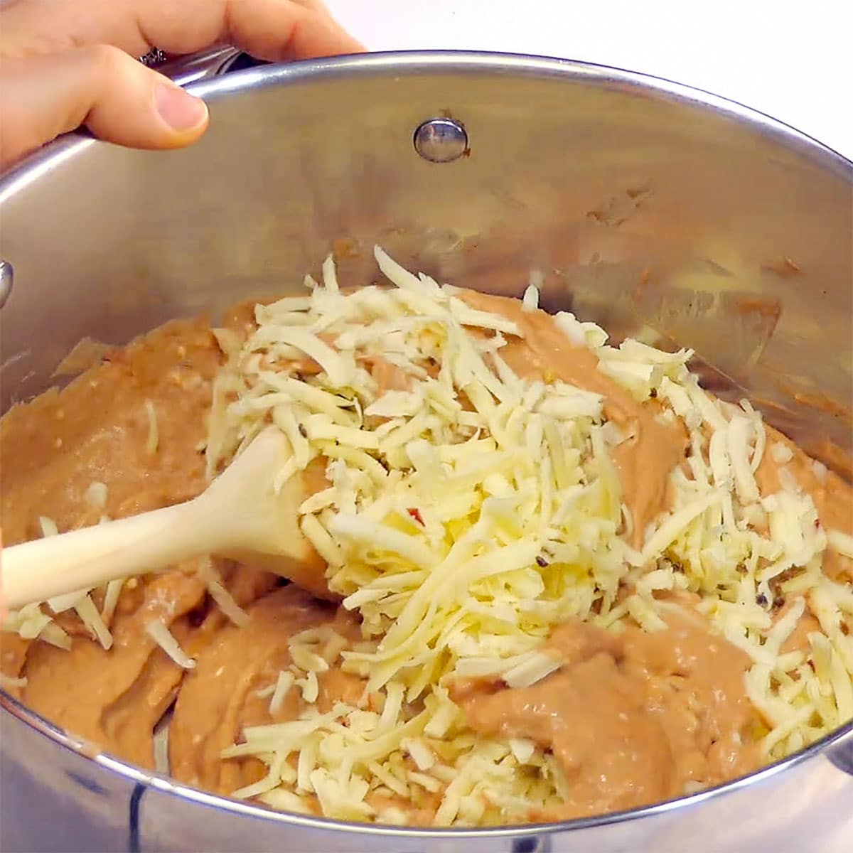 Adding cheese to pot.