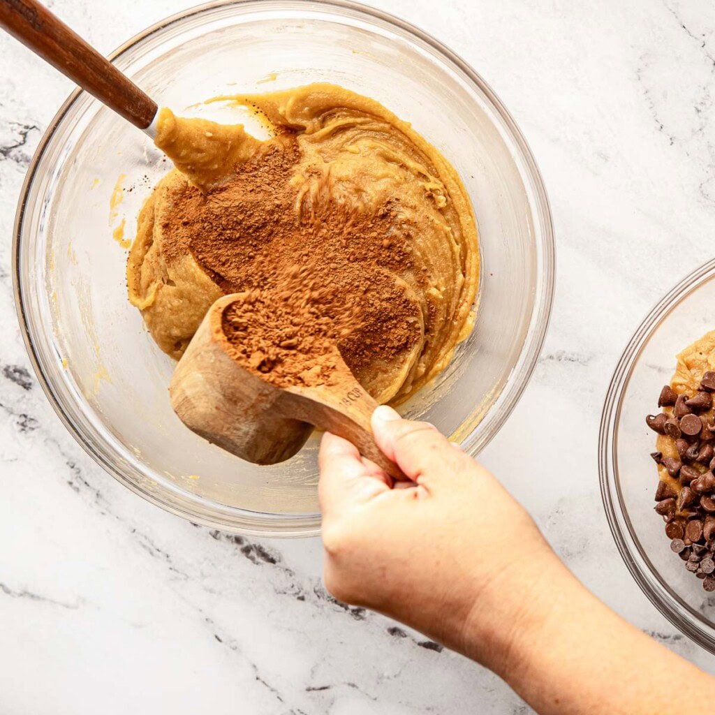 Adding cocoa powder to other bowl for brownie layer of Brookies recipe.