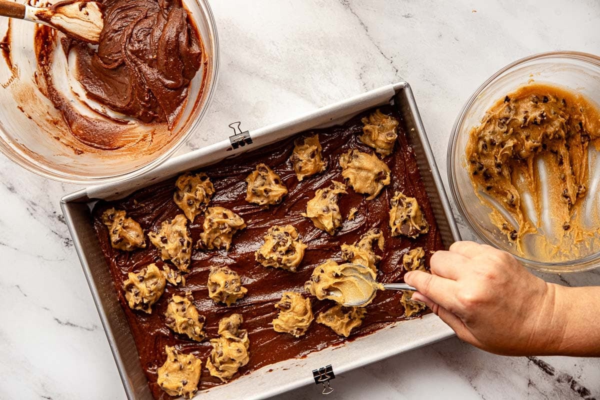 Dolloping cookie dough on top of brownie batter.