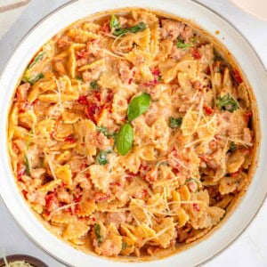 Creamy Sausage Pasta, aerial close-up in pot with garnish.
