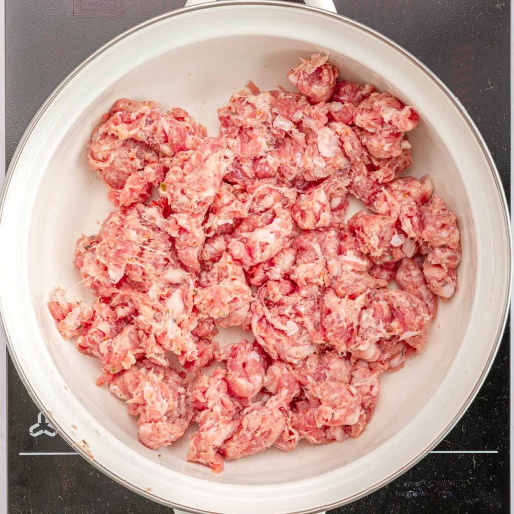 Italian sausage uncooked in pot.