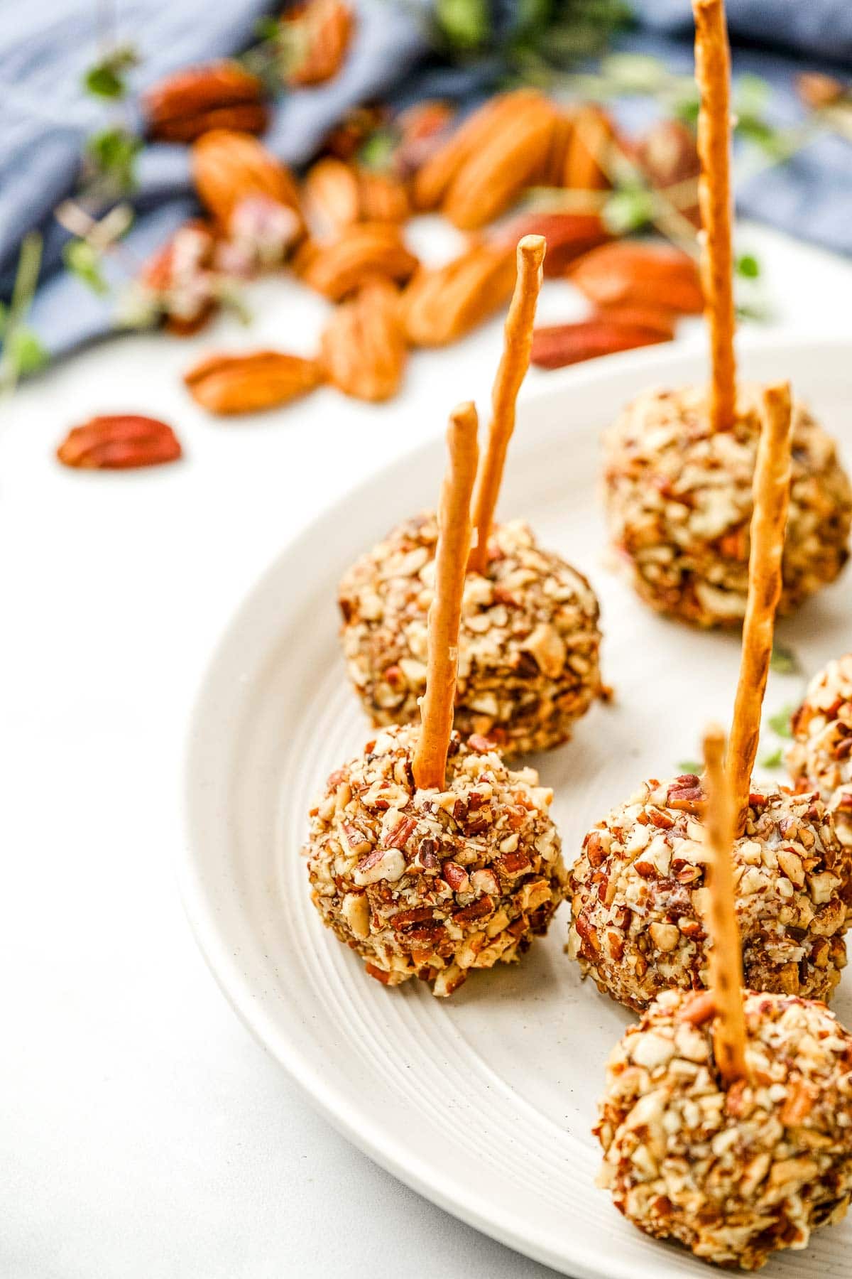 Mini Cheese Balls on plate with pecans in background.